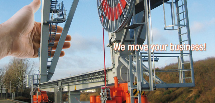 A hand is pushing a crane with a mounted motor-driven cable reel.